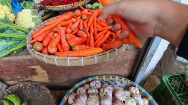 Birinci Sinema Kişisi: Endonezya 'nın Bandung kentindeki geleneksel bir pazarda taze, turuncu bebek havuçları seçmek. POV 4K çözünürlüklü geleneksel bir pazardan alışveriş görüntüsü.