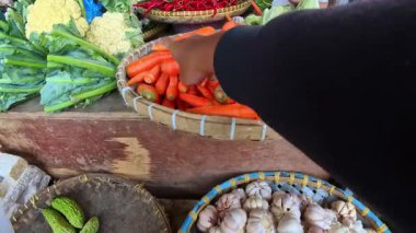 Birinci Sinema Kişisi: Endonezya 'nın Bandung kentindeki geleneksel bir pazarda taze, turuncu bebek havuçları seçmek. POV 4K çözünürlüklü geleneksel bir pazardan alışveriş görüntüsü.