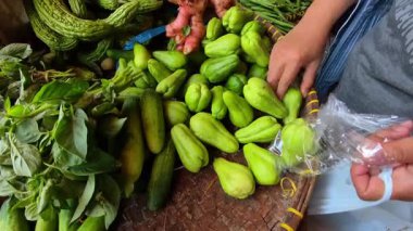 Geleneksel bir markette satılık küçük yeşil bir kabak yığınının videosu. Endonezya 'da geleneksel bir pazarda satılan yiyecek görüntüleri. 4K HD Çözünürlüğü