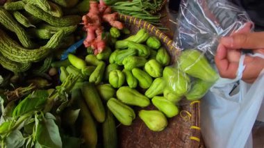 Geleneksel bir markette satılık küçük yeşil bir kabak yığınının videosu. Endonezya 'da geleneksel bir pazarda satılan yiyecek görüntüleri. 4K HD Çözünürlüğü