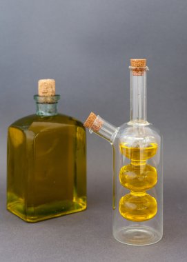 İki cam şişe zeytinyağı karanlık bir arka plan üzerinde