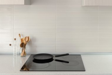 Pot ve tahta kaşıklar indüksiyon ocağı ile modern mutfak