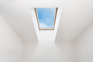 Mavi gökyüzü karşı bir tavan odasında modern açık ışıklık (mansard pencere)