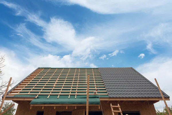Om metall kakel på taket. Hus under uppförande med skruvmejsel och takläggning järn — Stockfoto