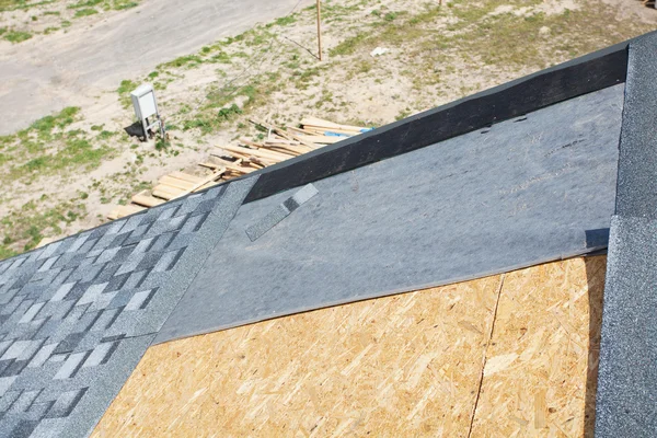 Installazione di tegole di asfalto tetto. Nuova casa in costruzione — Foto Stock