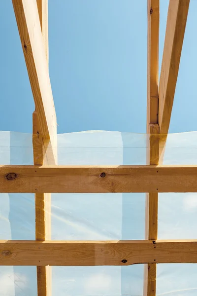 Wohnungsneubau vor blauem Himmel. Dachdeckerarbeiten. Holzkonstruktion — Stockfoto