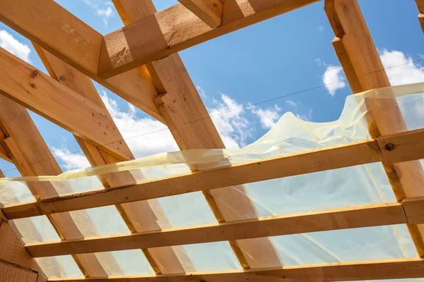 Nuova costruzione residenziale casa incorniciatura contro un cielo blu. Costruzione di tetti. Costruzione in legno — Foto Stock