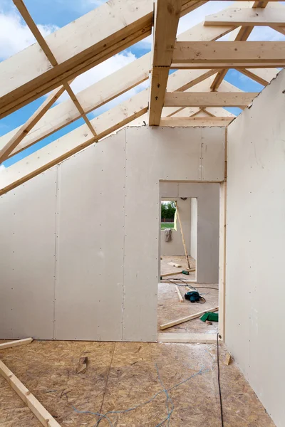 根据建筑用石膏板的阁楼房间。屋面施工室内。木制的屋顶框架房屋建设. — 图库照片