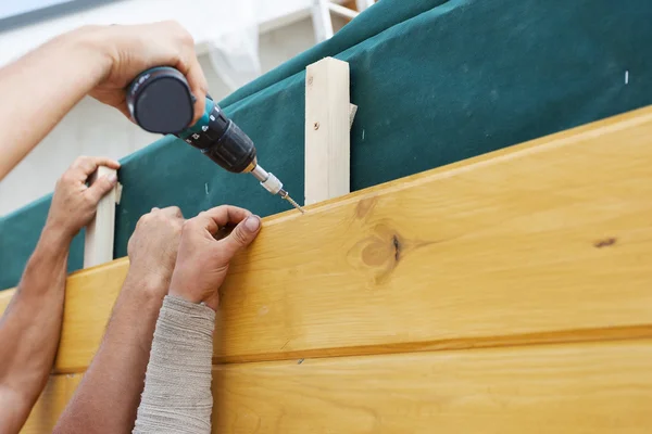Arbeiter installieren eine natürliche braune Kiefer Holz auf neue Haus im Bau — Stockfoto
