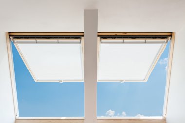 Mavi gökyüzü karşı bir tavan odasında modern açık tepe (mansard windows)