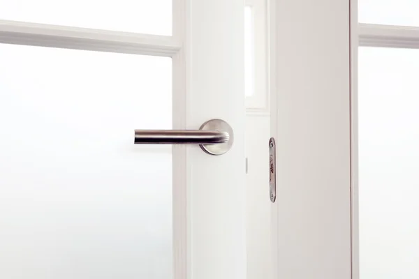 Mango de puerta metálica de acero en la nueva puerta blanca —  Fotos de Stock