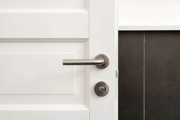 Open white door with metallic handle — Stock Photo, Image