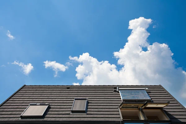 Panel de agua solar con dormitorios en un techo contra el cielo azul — Foto de Stock