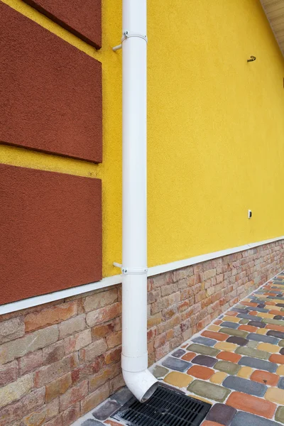 Nové dešťové hřbetu na žluté zdi — Stock fotografie