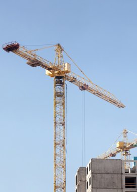 Mavi gökyüzüne karşı vinç ve inşaat alanı