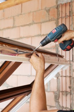 Plastik pencere montaj. İşçi çapa plaka tornavida ile ekler.