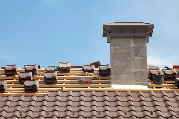 Um telhado em construção com pilhas de telhas prontas para fixar — Fotografia de Stock