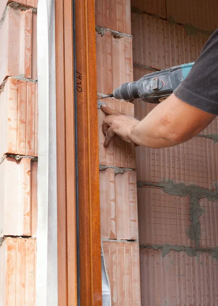 プラスチック窓設置労働者は、ネジ用の穴をドリルします。 — ストック写真