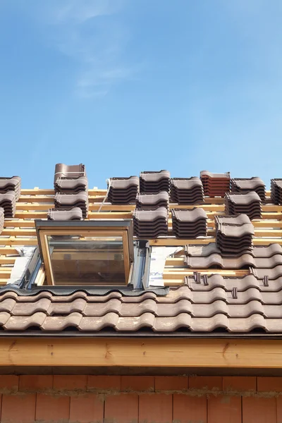 Casa in costruzione. Mattonelle di copertura con lucernario aperto — Foto Stock