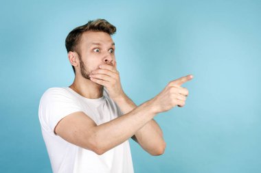 Hadi canım. Buna inanamiyorum. Heyecanlı ve şok olmuş beyaz tişörtlü, ağzı kapalı, elini uzatan, mavi fotokopi çekilen arka planda tek başına duran genç bir adamın yan görüntüsü.