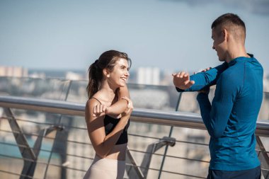 Takım çalışması aktivite konsepti. Mutlu genç arkadaşlar birlikte spor yapıyorlar, koşmadan önce egzersiz yapıyorlar, vücut esnetiyorlar.