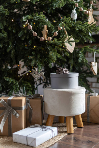 Concept of traditional new year and xmas celebrations. Vertical view of different gift box and present packages under fir tree in lovely cozy house