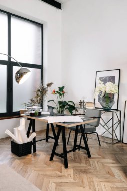 Uzak iş konsepti. Modern evdeki ev ofisinin modern iç tasarımı dikey görünümü. Laptop bilgisayar ve kağıt belgeler çalışma masasında.