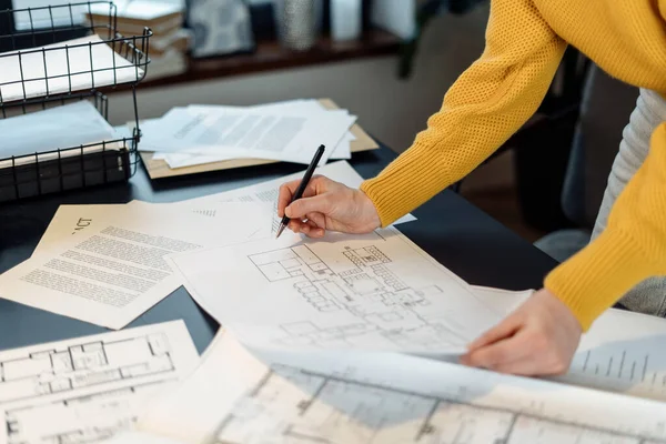設計図を持つ建築機関で働く実業家の作物のビュー 文書をチェックし オフィスでテーブルの後ろに立って 建物の改修のプロジェクトを作る — ストック写真