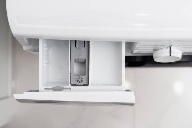 Çağdaş otomatik çamaşır makinesinde çamaşır tozu ya da yumuşatıcı için boş ve açık konteynır manzarası. Banyoda ev aletleri var.