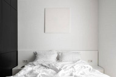 Çift kişilik süit odasındaki rahat yatağın üzerinde maket boyası olan bir otel dairesi. Sabah ışığı beyaz ve rahat yatak odasının içinde yumuşak yastıklar ve yorganla. Eğlence ve rahatlama konsepti