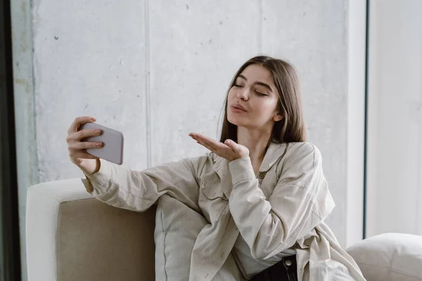 Mujer Joven Encantadora Sentada Sofá Sala Estar Haciendo Foto Selfie —  Fotos de Stock