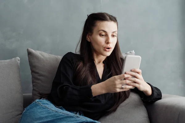 Surprised Young Woman Using Smartphone Device While Sitting Sofa Living — Stock Photo, Image