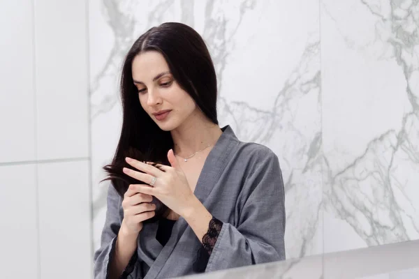 Güzel Esmer Genç Bir Kadın Banyodaki Mükemmel Sağlıklı Saçlarına Bakıyor — Stok fotoğraf