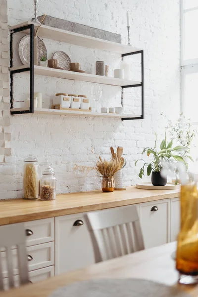インテリアとホームキッチンのインテリア デザインのクローズアップ 白いレンガの壁 テーブルで近代的なガラス装飾と現代のスカンディナヴィアの家 台所用品で木製の家具で料理を作る — ストック写真
