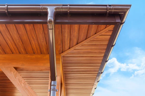 New brown copper gutter under a cloudy blue sky — Stock Photo, Image