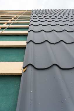 Ev yapım aşamasında. Çatı metal kiremit, tornavida ve çatı demir