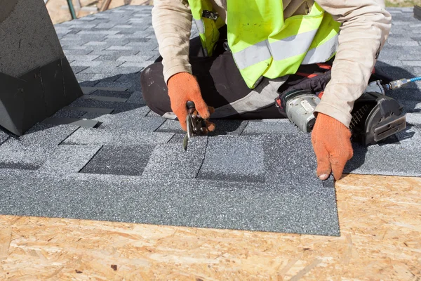 Worker cuts shingles witk scissors — Stock Photo, Image