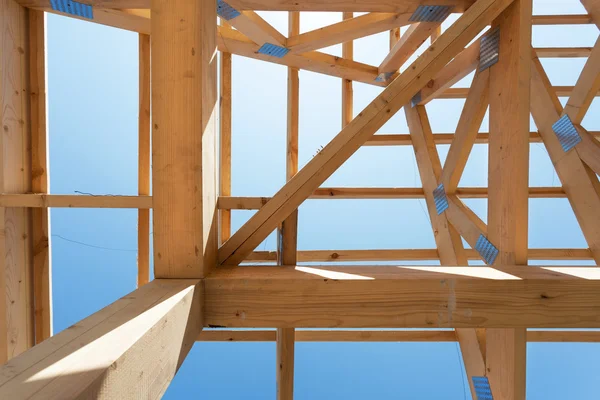 Nova casa de construção de madeira residencial enquadrando contra um céu azul — Fotografia de Stock