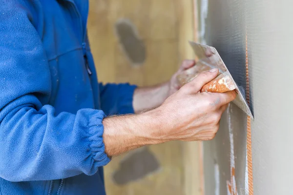 Pekerja konstruksi dengan kayu panjang plastering dinding — Stok Foto