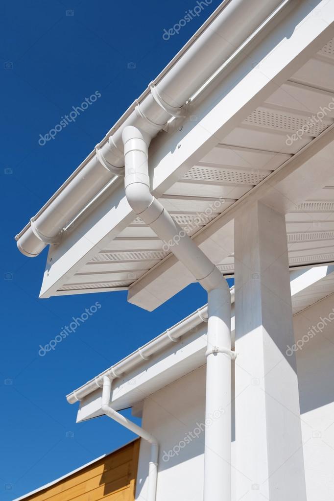 New rain gutter on a white home against blue sky