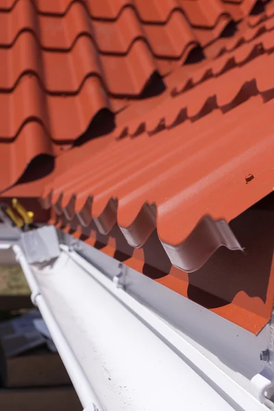 Nova telha de metal vermelho com calha de chuva branca — Fotografia de Stock