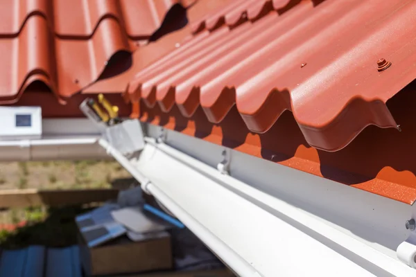 Nové červené kovové dlaždice s bílým dešťových svodů — Stock fotografie