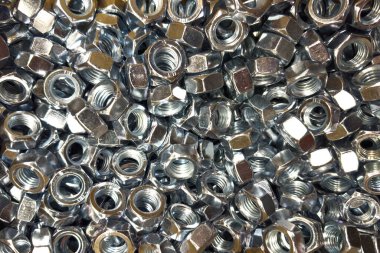 Parlak metal fındıklar atölyedeki bir kompartımanı dolduruyor, inşaat ve marangozluk için kullanılan aletleri sergiliyor, çelik ve imalat endüstrisinin kalitesini vurguluyor.