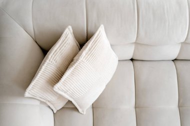 Parlak ve modern yerleşim yerlerinde yumuşak yastıklarla süslenmiş beyaz bir kanepe. Dekoratif yastıklı kanepe. Minimalist tasarım odanın zarafetini arttırır. Mobilya ve ev dekorasyonu