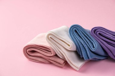 Renkli çorapların hoş bir görüntüsü, yumuşak pembe bir arka planda, reklam için fotokopi alanı ile birlikte.
