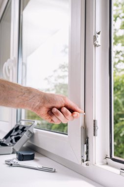 Becerikli bir tamirci bir PVC penceresi kurmak için çalışır, kareye metal elementleri ayarlar, hex anahtar aracı kullanır. Konut konutunun geliştirilmesi, işlevsellik ve yaşam alanının dayanıklılığı