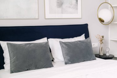 Bu davetkar otel odası, pürüzsüz gri yastıklı, minimalist dekorlu, ve biraz zarafet katarak misafirler için rahat ve rahatlatıcı bir atmosfer yaratıyor..