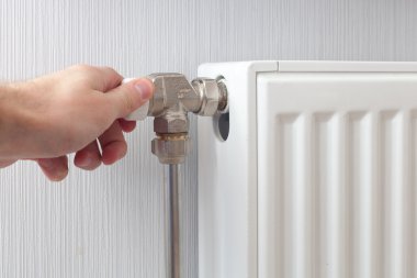 Radyatör ayarlama portre. Adamın elini radyatör sıcaklığı ayarlama.