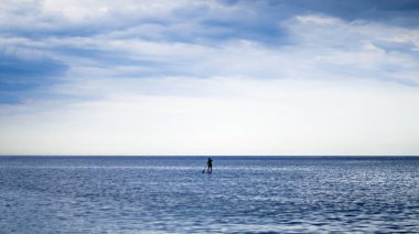 Akdeniz 'in sakin sularında sörf yaparken dengeyi sağlayan bir adam.