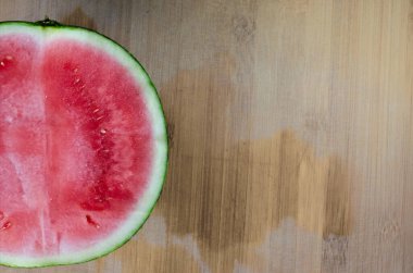 Bir köşede yarım karpuz ve altta ahşap bir masa..
